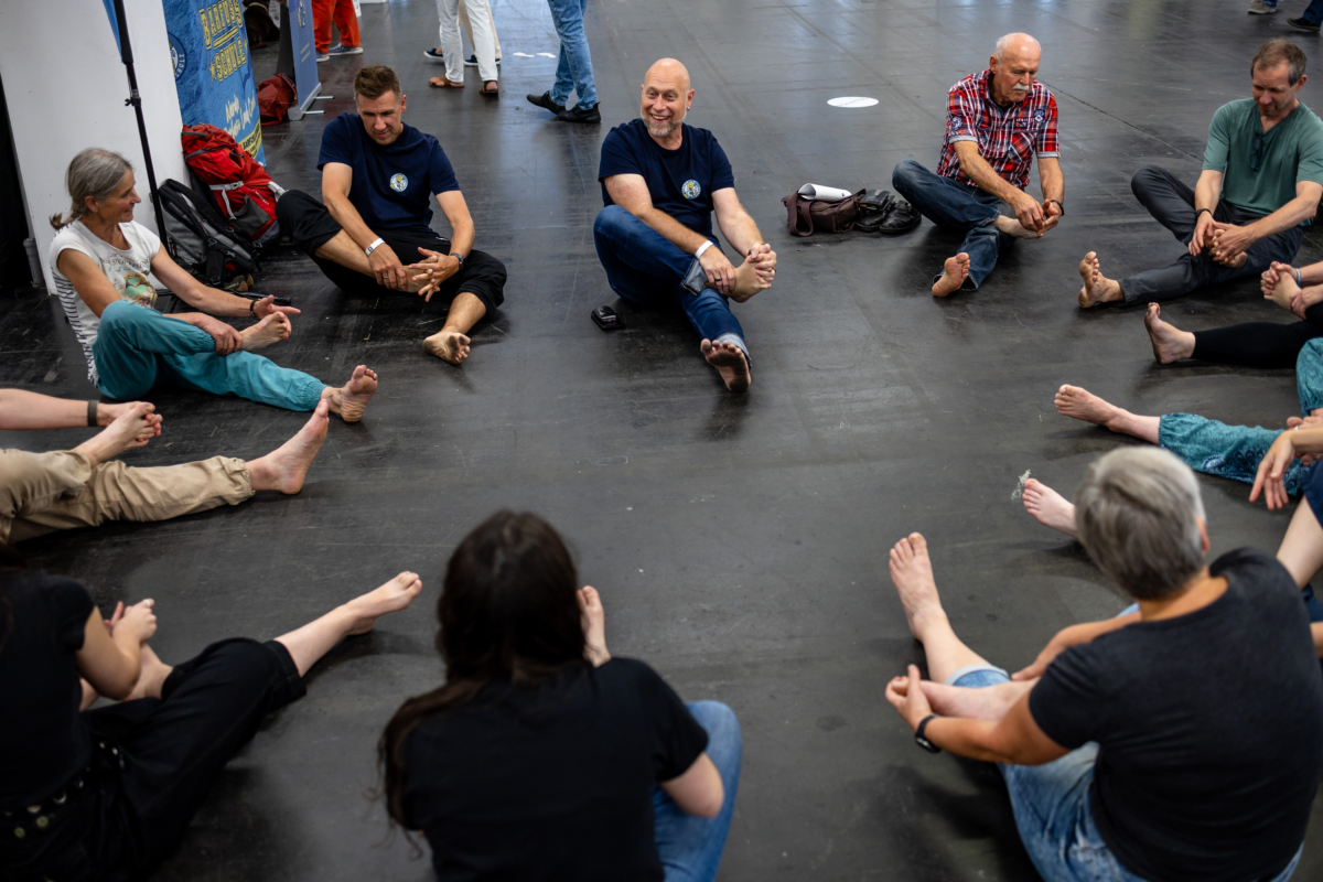 Besucher sitzen im Kreis und massieren ihre Füß bei Messe BAREFooT